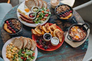 a table topped with plates of food and bowls of fruit