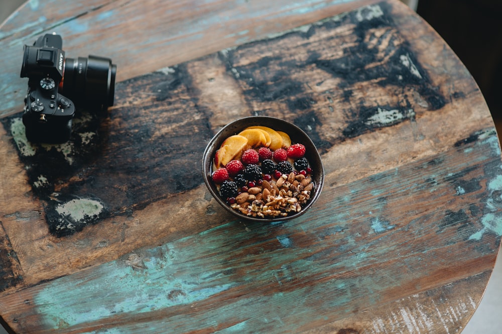 a bowl of fruit and nuts on a table