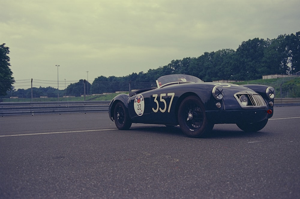 a black sports car driving down a road