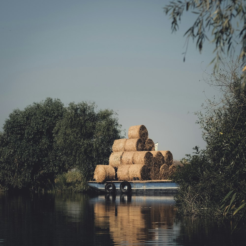 a boat filled with hay floating on top of a lake
