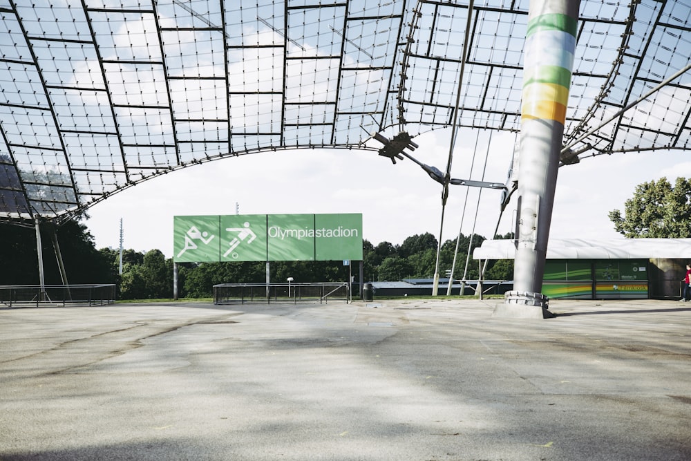 an empty tennis court with a large sign in the background