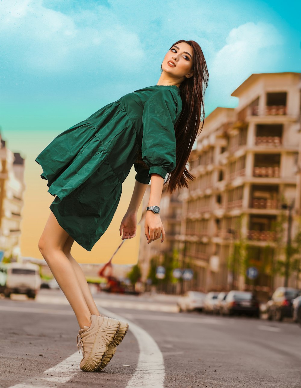 a woman in a green dress is crossing the street