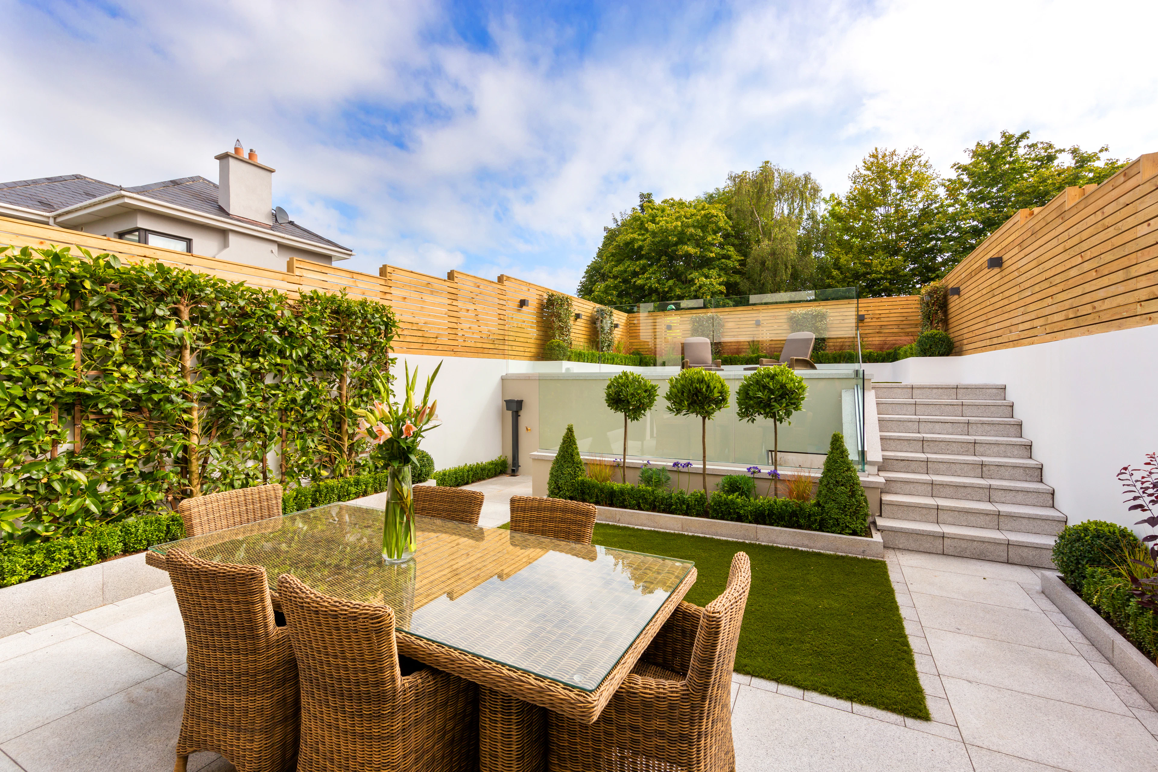 Patio with table and chairs beside a fence
