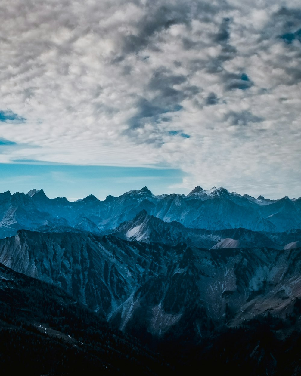 a view of a mountain range with clouds in the sky