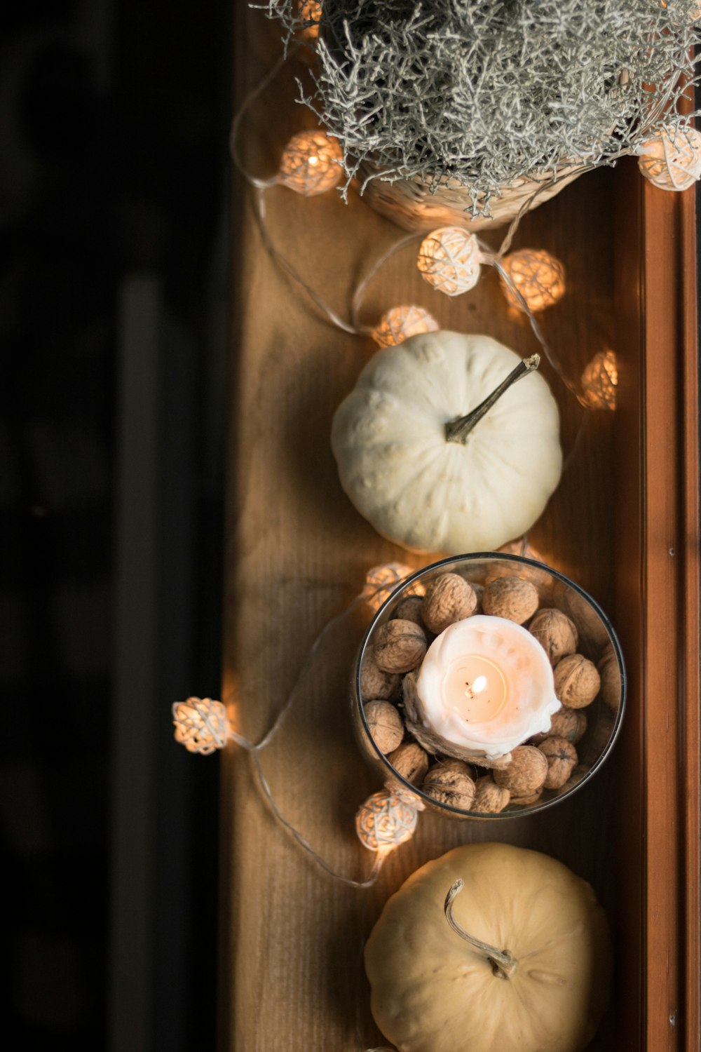 a table topped with a bowl of nuts and a candle