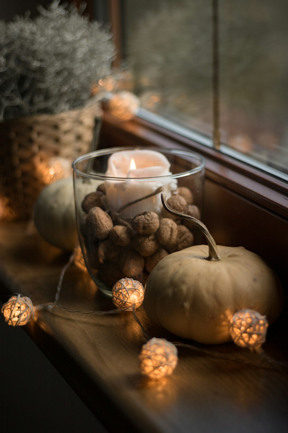 a window sill with a candle and some pumpkins