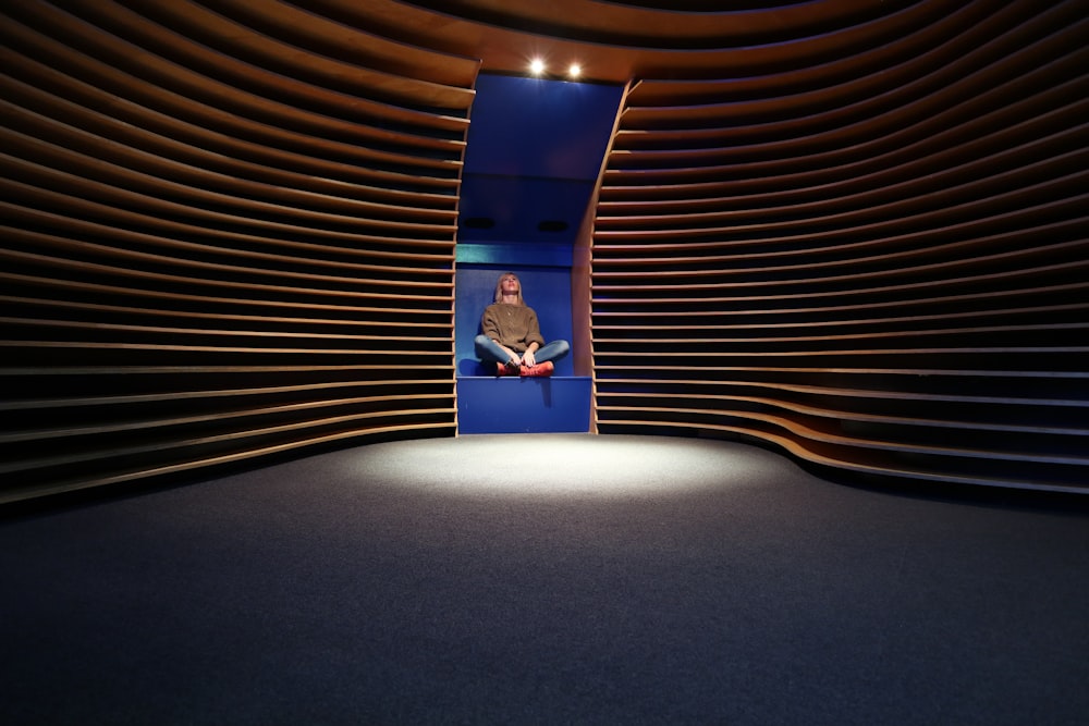 a man sitting on a blue chair in a room