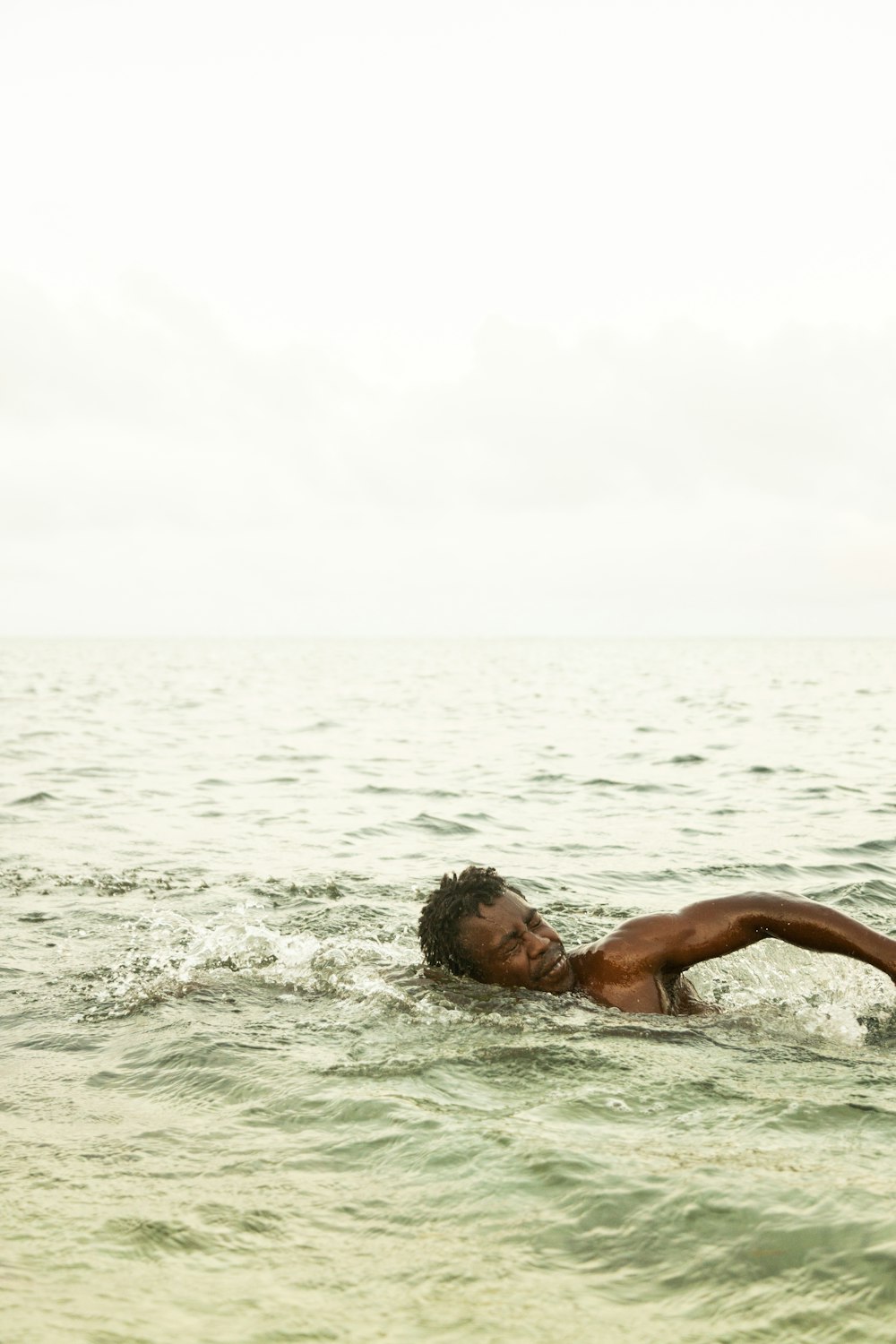 a man swimming in the ocean on a surfboard