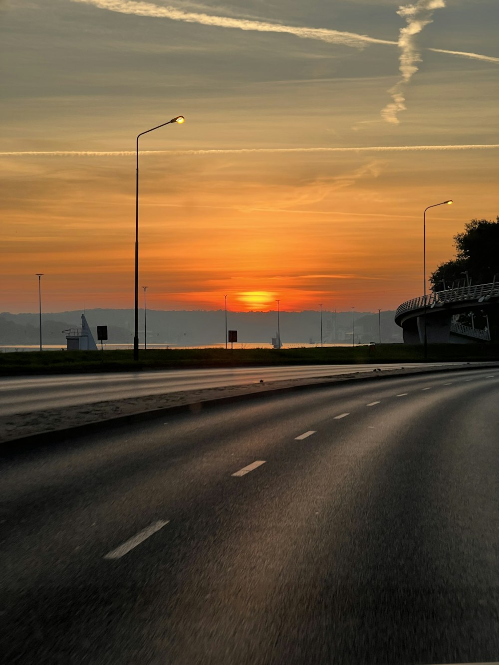 the sun is setting on the horizon of a highway