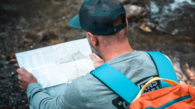 a man with a backpack looking at a map