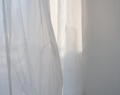 a white curtain with a cat sitting on top of it