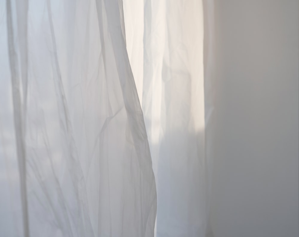 a white curtain with a cat sitting on top of it