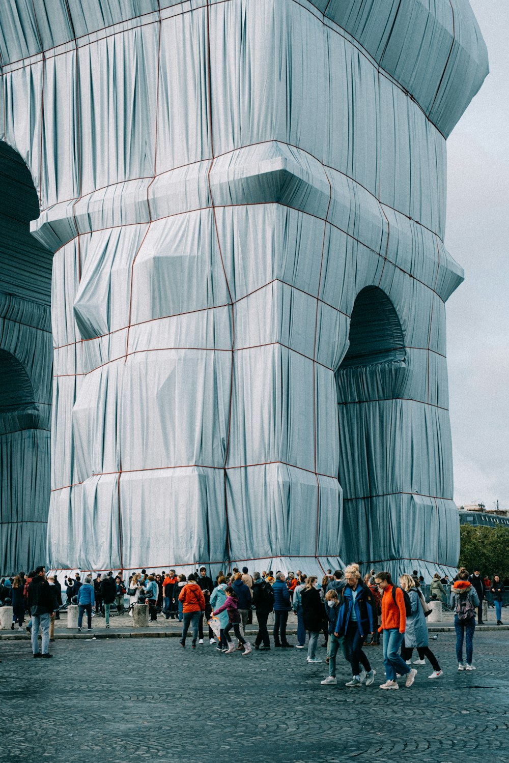 a large group of people walking around a building