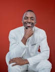 a man in a white suit posing for a picture