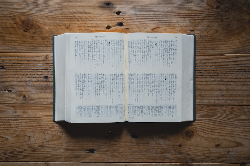 un livre ouvert posé sur une table en bois