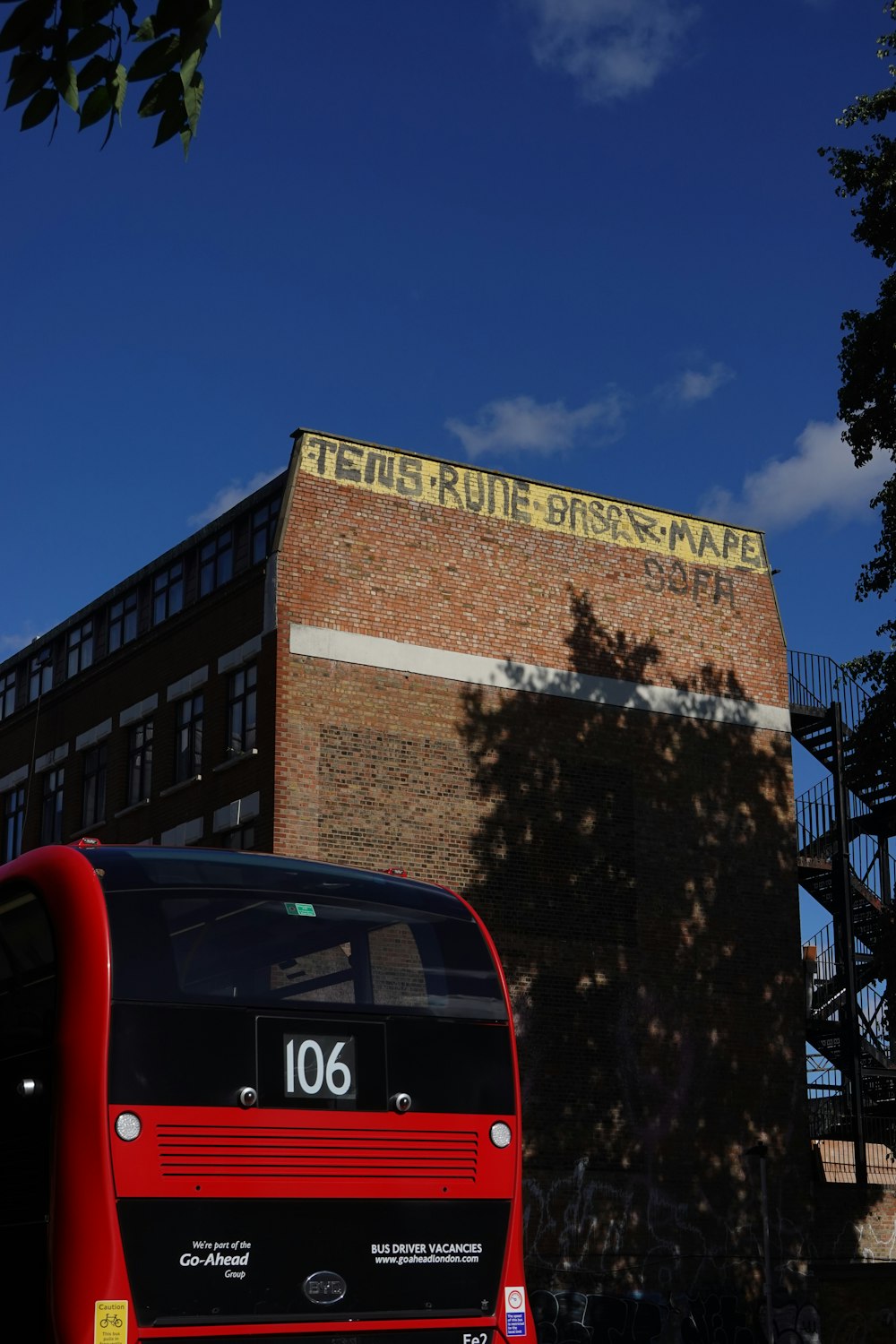 a red bus parked in front of a brick building