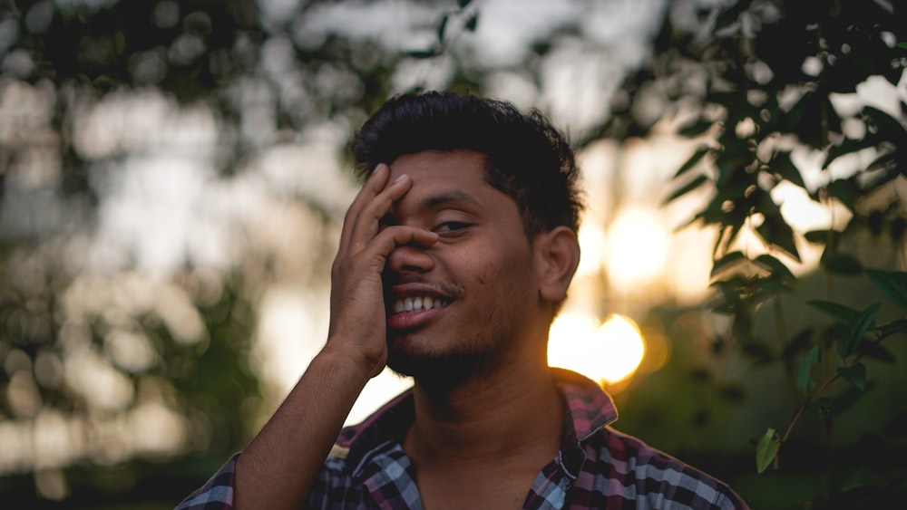 a man holding his hand up to his face