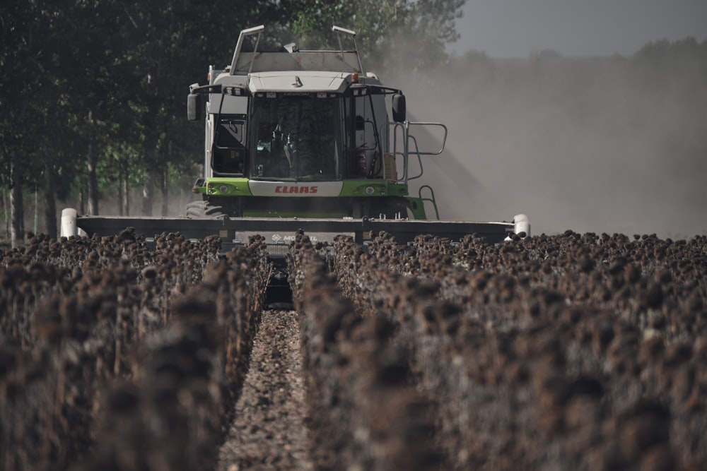 a green and white truck driving through a field