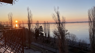 Balcony view overlooking a tranquil lake at dawn.
