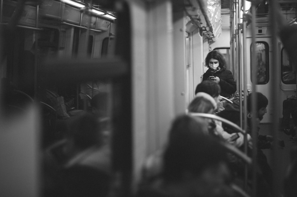 a black and white photo of a woman on a train