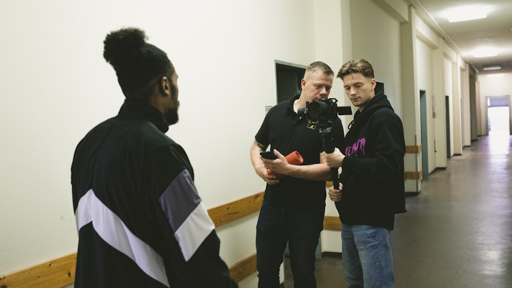 a group of men standing around each other in a hallway