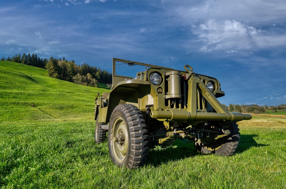 a green military truck parked in a field