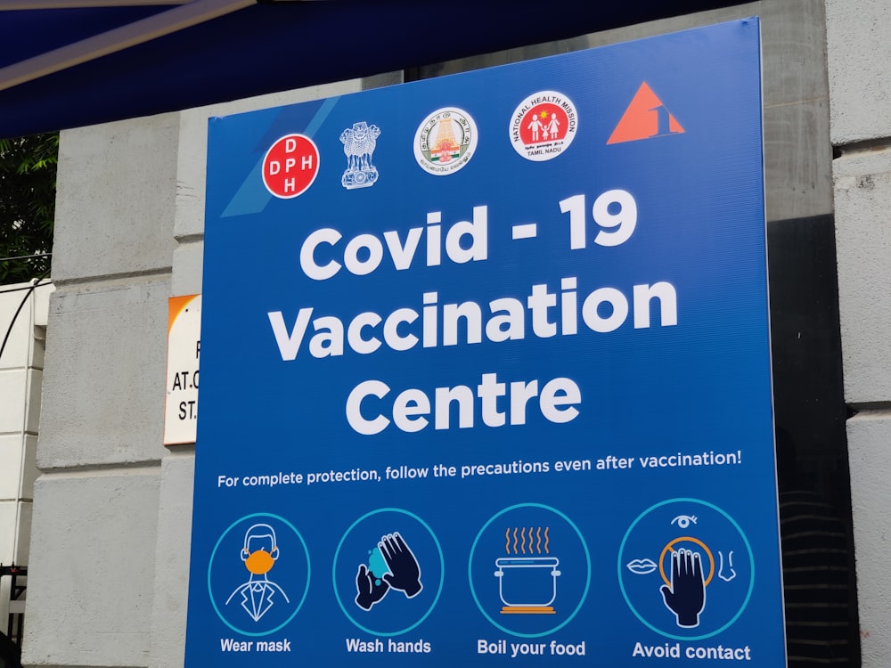 COVIDD - 19 예방 접종 센터라고 표시된 파란색 표지판