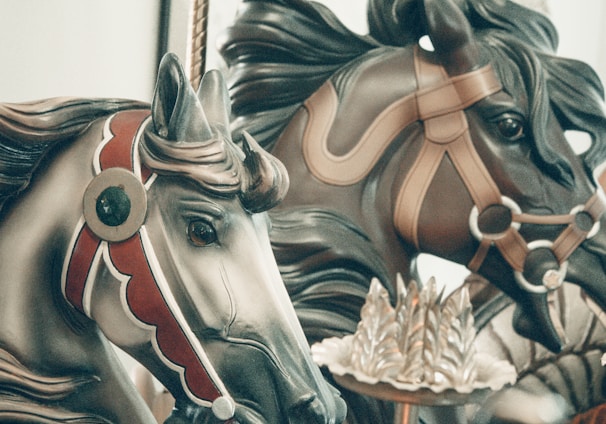 a close up of two horses on a carousel