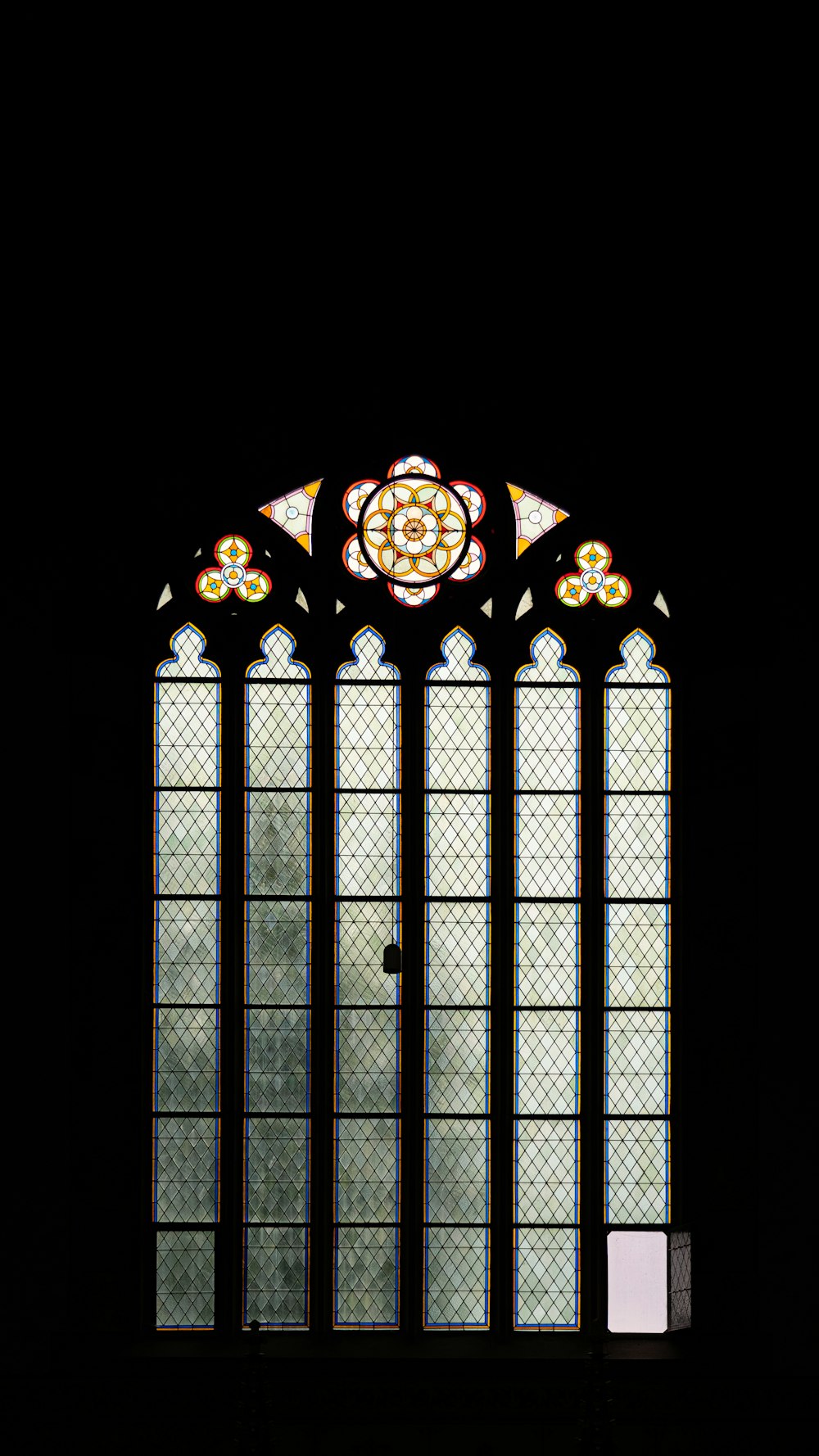 a large stained glass window in a dark room