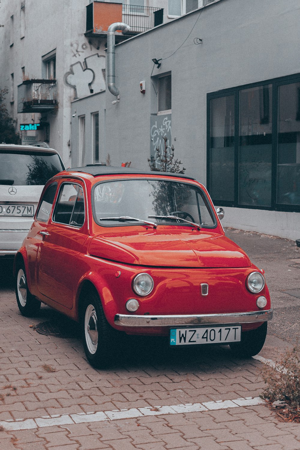 a red car is parked on the side of the road