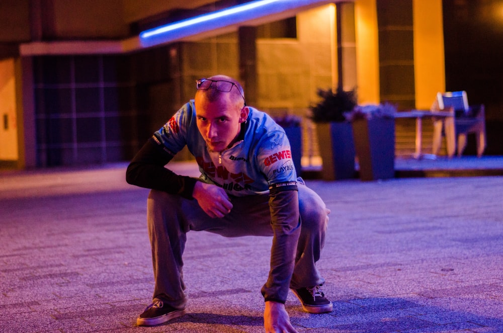 a man kneeling down on a skateboard in a parking lot