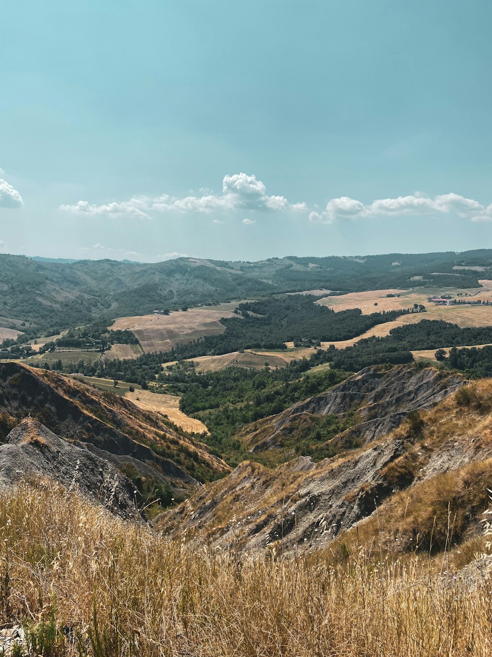 a view of a valley with rolling hills in the distance