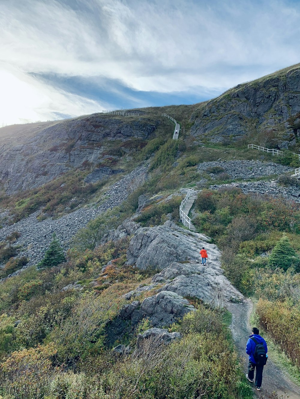 a man is walking up a path in the mountains