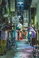 a narrow alley way with many signs hanging from the ceiling