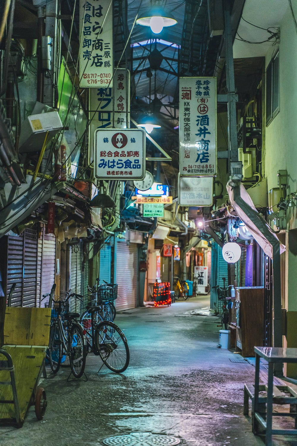 eine schmale Gasse mit vielen Schildern, die von der Decke hängen