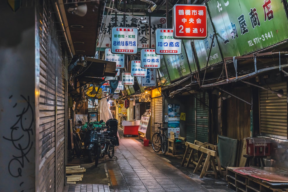 a narrow alley with signs hanging from the ceiling