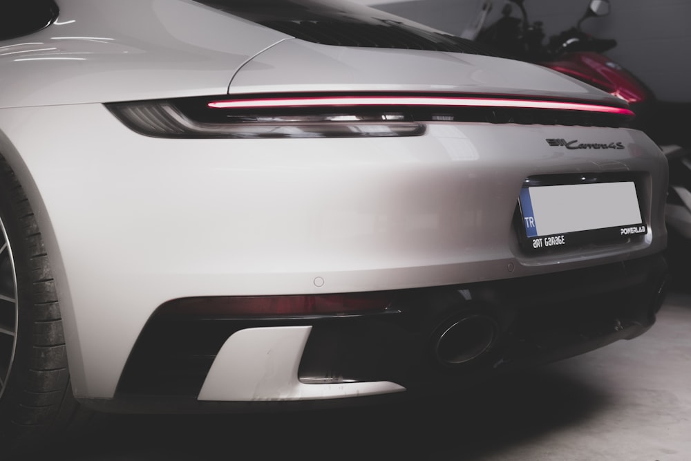 a close up of the rear end of a white sports car