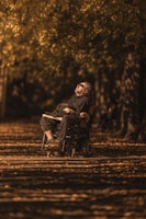A smiling patient using a specialized wheelchair outdoors on a sunny day.