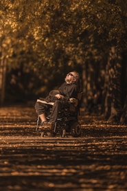 a man sitting in a wheel chair in a park