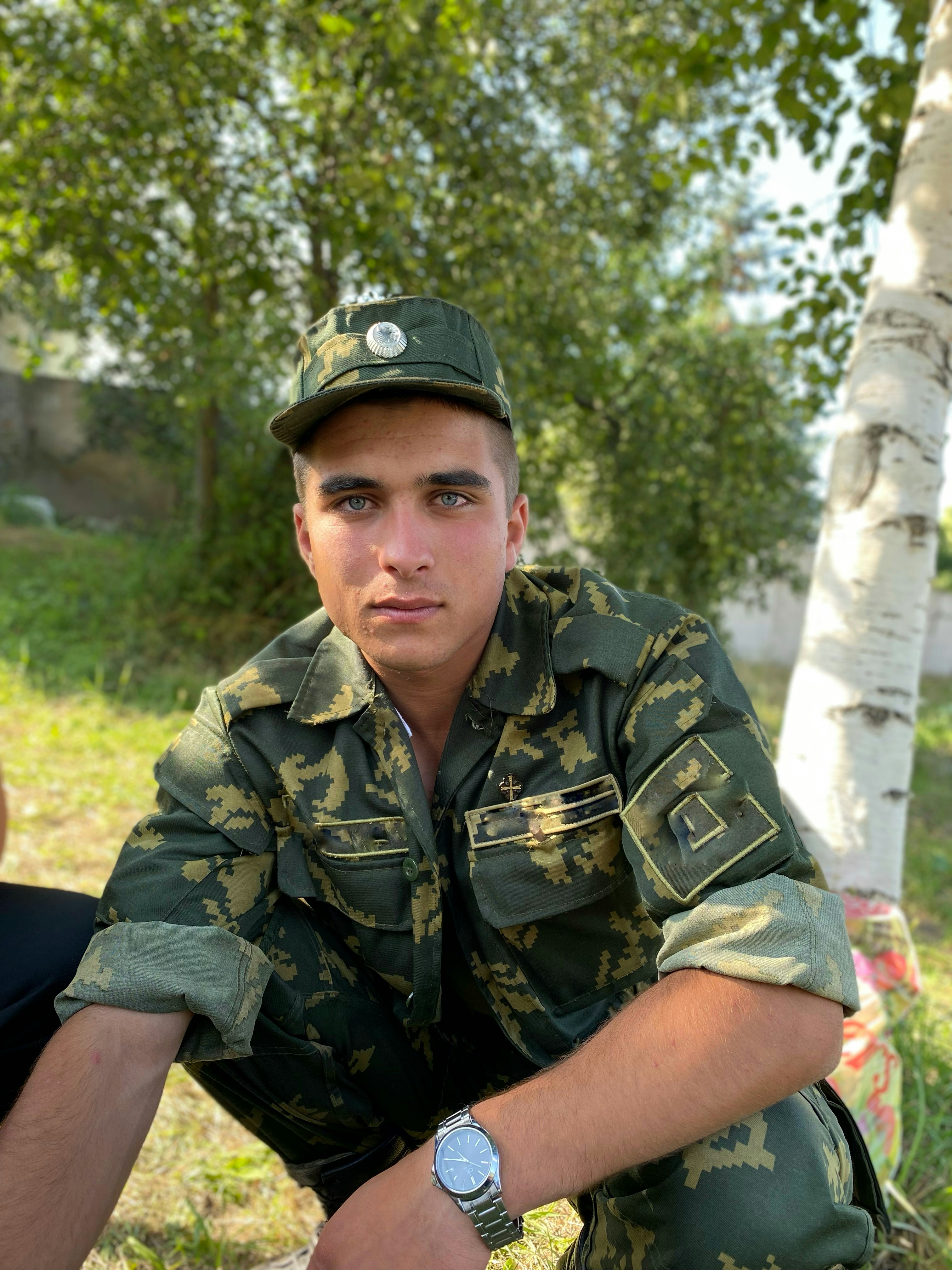 a man in a military uniform sitting on the ground