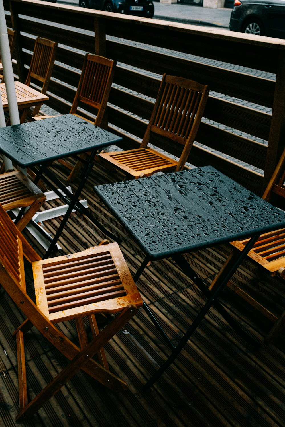a row of wooden chairs sitting on top of a wooden deck