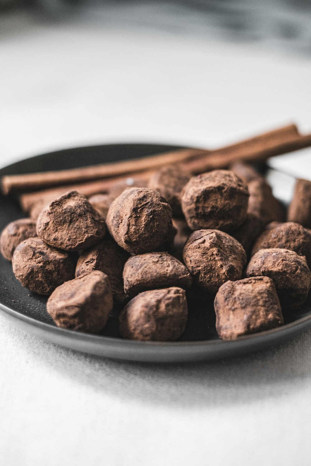 a plate of chocolate balls and cinnamon sticks