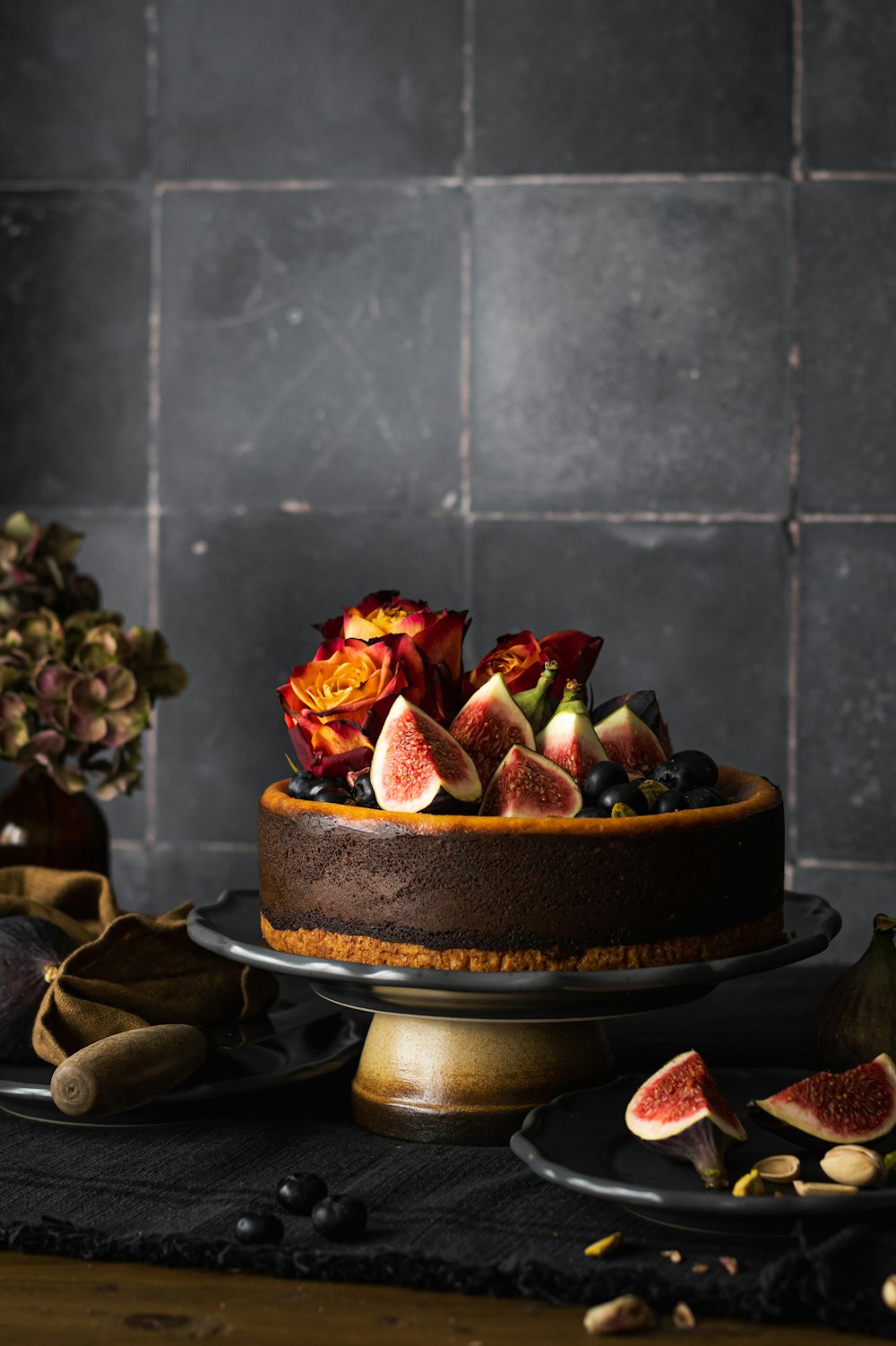 a cake with figurines and flowers on a table