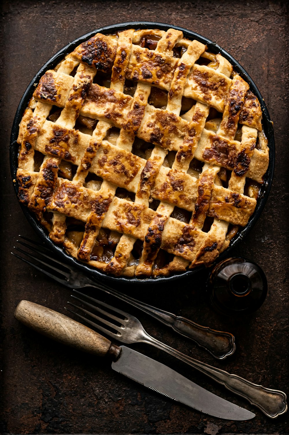 a pie sitting on top of a table next to a knife and fork