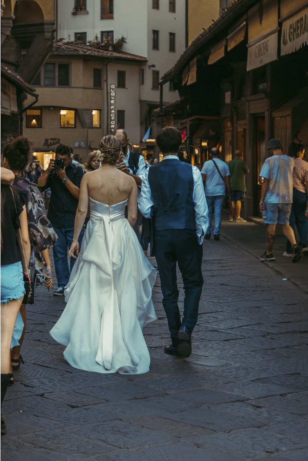 a bride and groom walking down the street