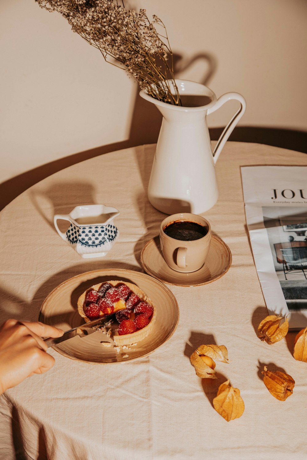 a table topped with a plate of food and a cup of coffee