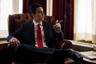 a man sitting in a chair smoking a cigarette