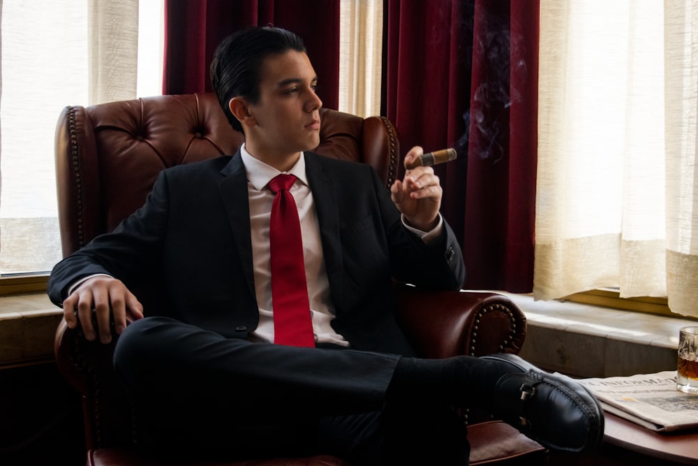 a man sitting in a chair smoking a cigarette