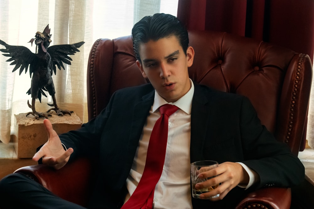 a man in a suit and tie sitting in a chair