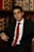 a man in a suit and tie sitting in a chair